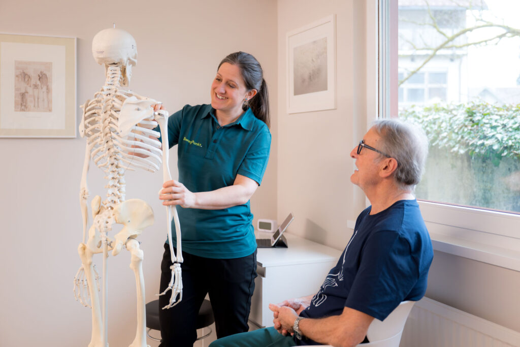 Gabriele Lechner erklärt einem Patienten die Behandlung anhand eines Modells